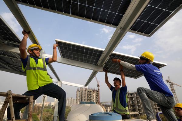 Solceller installeres på taket av et bolighus i utkanten av Indias hovedstad New Delhi. Mens utslippene i India vokser kraftig, bidrar solceller til å bremse utslippsveksten på verdensbasis. Foto: Manish Swarup / AP / NTB