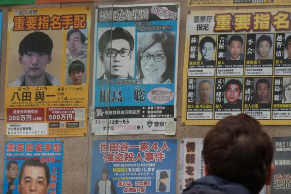 En etterlyst-plakat for Satoshi Kirishima (øverst i midten), viser 70-tallsterroristen slik han så ut rundt tiden da han var en del av Øst-Asia Anti-Japan Væpnede Front, som angrep flere japanske bedrifter. Foto: AP Photo/Eugene Hoshiko