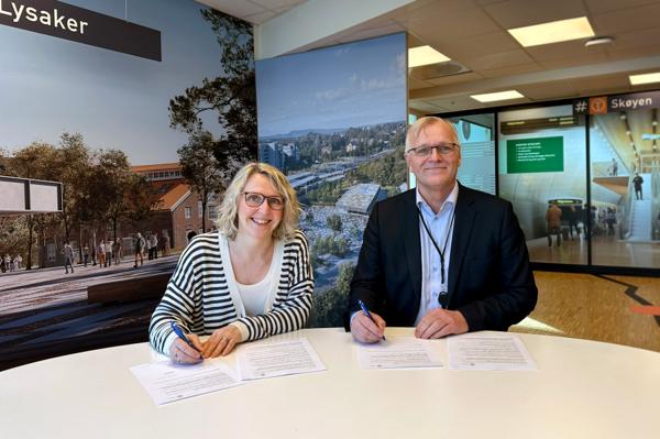 Irene Måsøval, etatsdirektør i Fornebubanen og Arild Moe, administrerende direktør i NRC Group Norge, signerer kontrakten. Foto: Fornebubanen