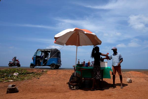 Kald drikke kommer godt med på en varm dag i Mahawewa, nord for Colombo på Sri Lanka. En ny studie viser at klimaendringene kommer til å koste 38 billioner dollar per dag på verdensbasis innen 2050. Foto: Eranga Jayawardena / AP / NTB.