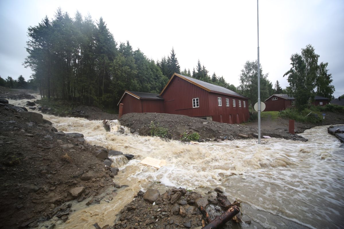 Kraftig regnvær gjør at bekker og elver går over sine bredder på Lillehammer natt til tirsdag, noen som preget morgentimene tirsdag. Her er det bekken Skurva som bidrar til at Nordseterveien er blitt et vassdrag. Foto: Geir Olsen / NTB scanpix