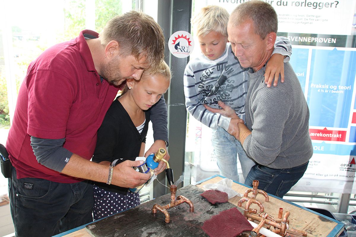 Regine Solhøi (12) lodder lysestake med hjelp fra Are Skaar Nielsen. Lillebror Reinert (11) og pappa Inge Solhøi følger spent med.