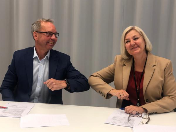 Rune Andersstuen (Veidekke) og Eli Grimsbyg (Oslobygg) signerer kontrakten for Hartvig Nissen videregående skole. Foto: Oslobygg