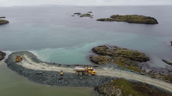 En stor steinfylling skal blant annet gi plass til anleggsvei og til slutt en stor rundkjøring for den ferdige Rogfastforbindelsen. Dronefoto: Sindre Sverdrup Strand