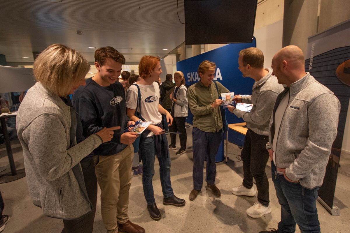 Tredjeårsstudentene Sigurd Norang (fra venstre), Eskild Fredriksen og Erik Kollbye ved Bygg og miljøteknikk på NTNU får her vite at de kan få studielånet sitt strøket hvis de lykkes i Skanskas konkurranse.