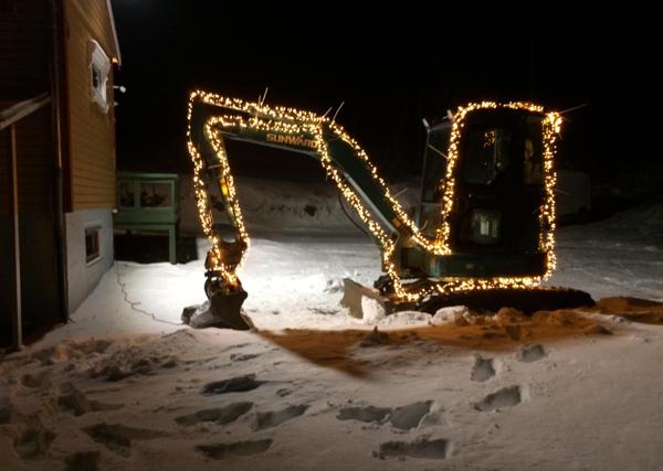 Maskinentreprenør Arild Ferdinand S. Johansen fra Vestvågøy i Lofoten har laget sin egen tradisjon med å lyspynte gravemaskin og traktorer før jul, noe som vekker oppmerksomhet hos forbipasserende på E10. Foto: Privat