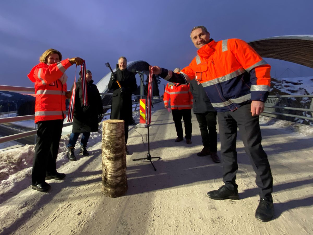 Samferdselsminister Jon-Ivar Nygård svingte øksa og kuttet snora på ny E16 i Jevnaker med assistanse fra vegdirektør Ingrid Dahl Hovland og Skanska-direktør Ståle Rød. Under åpningen trakk Skanska og Vegvesenet frem at det er oppnådd store kutt i klimagassutslippene i anleggsperioden. Foto: Per Kollstad.