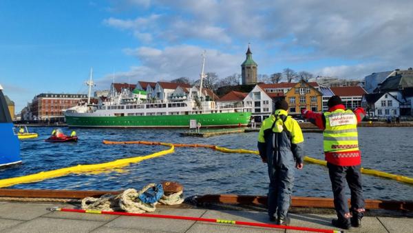 Lenser er lagt ut for å hindre spredning av olje og diesel i havnebassenget i Stavanger der hvor Multiconsults båt sank. Foto: Multiconsult