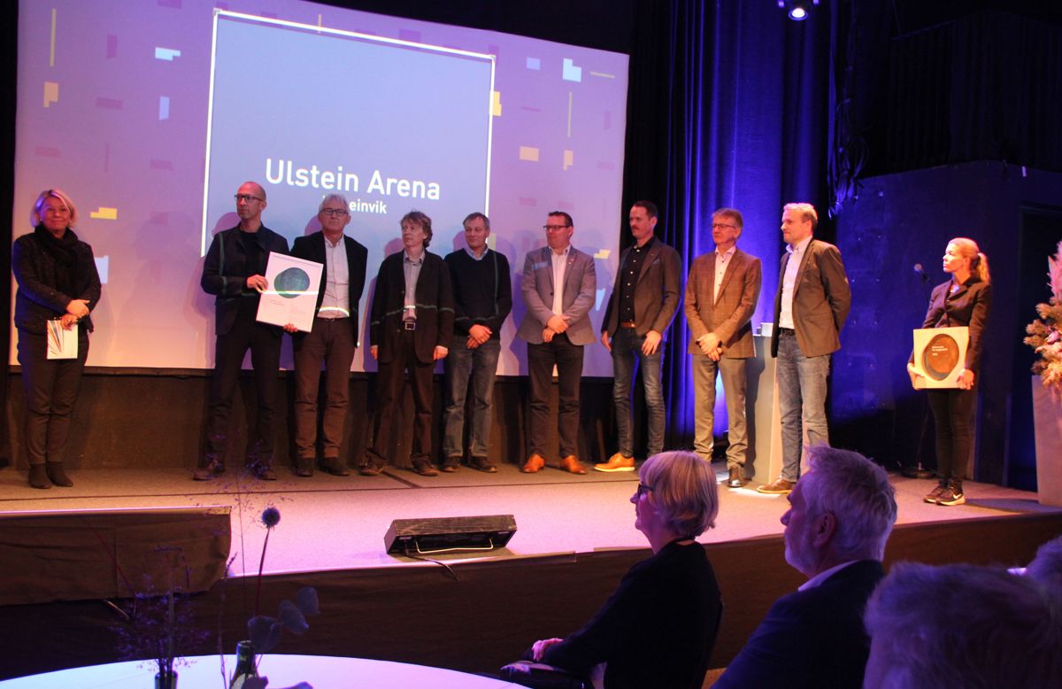 Det var stolte vinnere fra Ulstein Arena som tok imot Statens pris for byggkvalitet fra kommunalminister Monica Mæland. Foto: Svanhild Blakstad