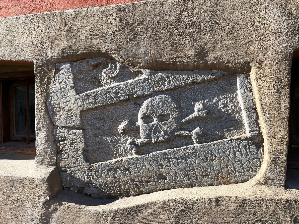 Det piratflaggliknende symbolet viste seg å være restene av en gravstein fra 1600-tallet. Dødninghoder med lårbein lagt i kors var vanlig i mange århundrer. Det ble hyppig brukt på gravmonumenter, og symboliserte kjødets forgjengelighet og død. Og for å minne om at sjelen, derimot, hadde evig liv. Foto: Trond Joelson