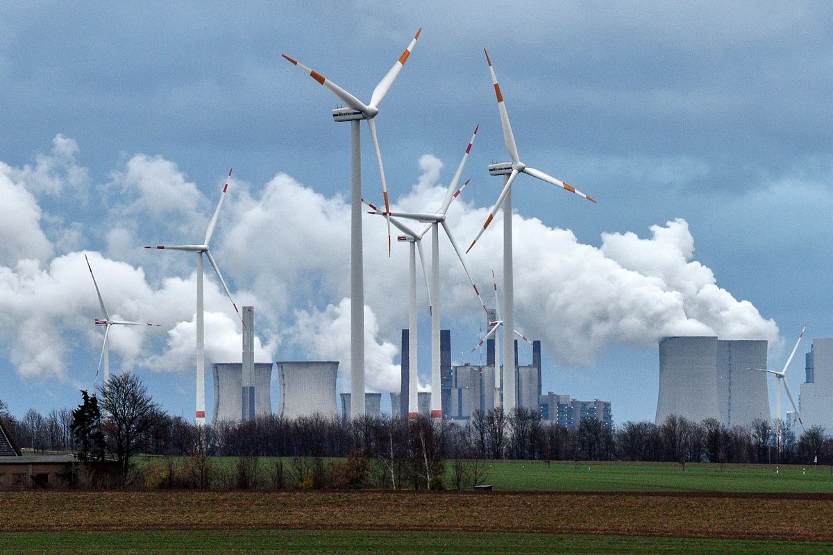 Vindturbiner foran et kullkraftverk nær Jackerath i Tyskland. Miljøeksperter peker på at sol- og vindkraft vil spille en avgjørende rolle i det grønne skiftet. Foto: AP / NTB