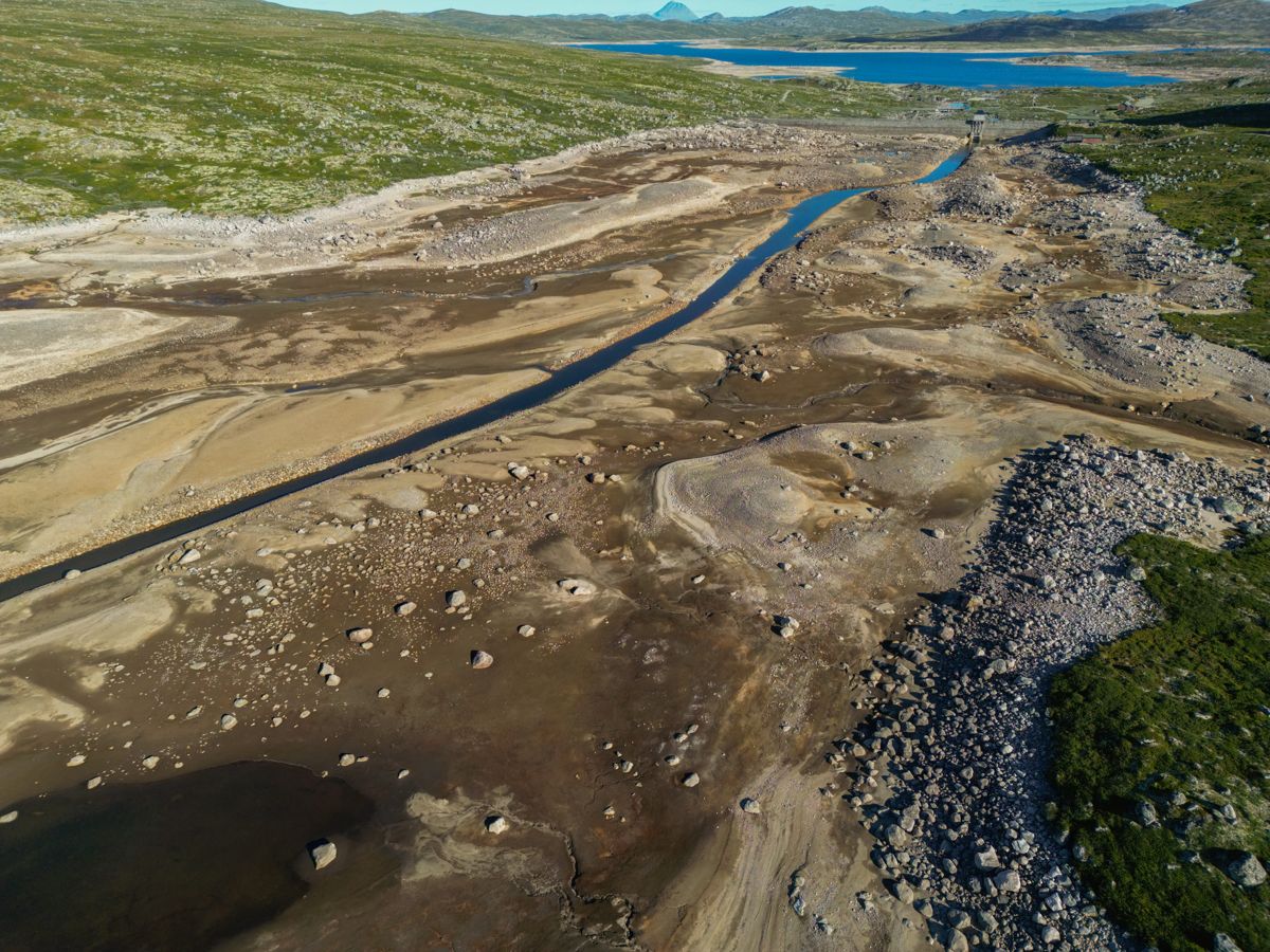 Lav vannstand i Mårvatn tidligere i sommer. Sørenden er nesten helt tørrlagt der hvor det er demmet opp, før vannet renner videre ut i Kalhovdfjorden. Disse er del av flere regulerte vann sør på Hardangervidda i Telemark. Foto: Ørn E. Borgen / NTB