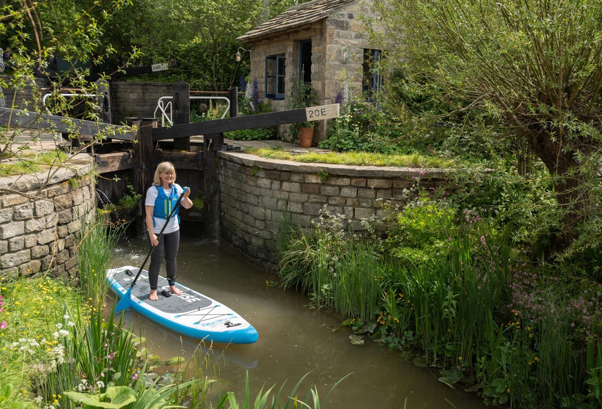 <i>Paddleboarder Jo Mosely poses in The Welcome to Yorkshire show garden at the RHS Chelsea Flower Show during press day in London. Foto: Suzanne Plunkett/RHS</i>