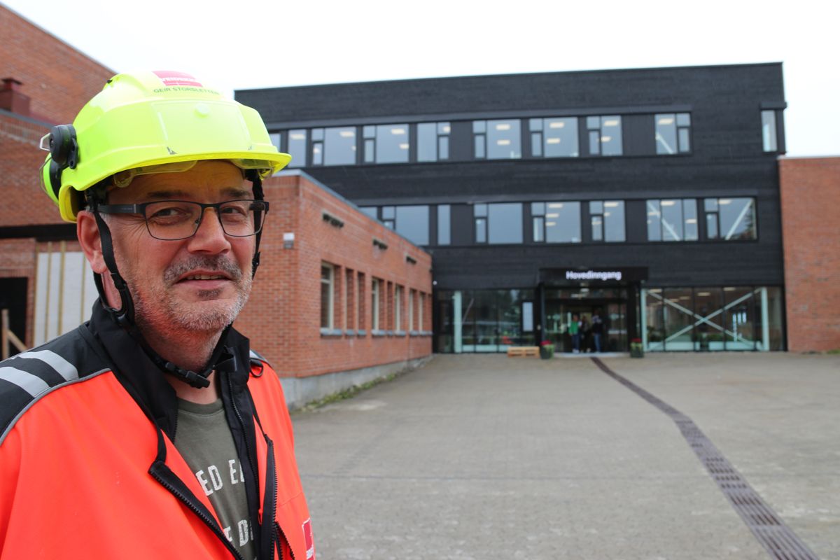 – Vi er bra i rute, sier prosjektleder Geir Storsletten i Veidekke Bygg. I bakgrunnen ser vi det ferdigstilte nybygget som knytter sammen eksisterende bygningsmasse ved Raufoss videregående skole. Foto: Ådne Homleid