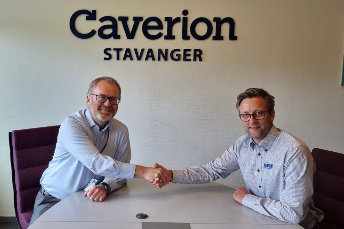 Administrerende direktør Knut Gaaserud i Caverion signerer kjøpsavtalen med daglig leder Eivind Jørgensen i Simex Klima & Kulde. Foto: Caverion