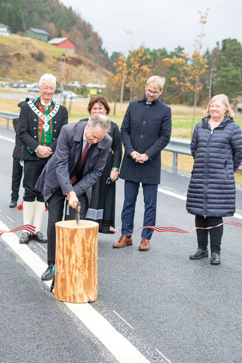 Samferdselsminister Jon-Ivar Nygård (Ap) markerer åpning av veien ved å hugge over et bånd med en båtbyggerøks, som det passer seg i oselverens rike.