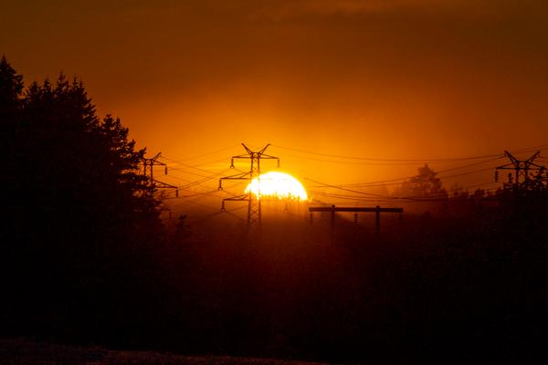 Solen vil skinne på strømprodusentene og eierne av kraftverk i år. Her ser vi strømmaster i solnedgang i Follo. Foto: Håkon Mosvold Larsen / NTB
