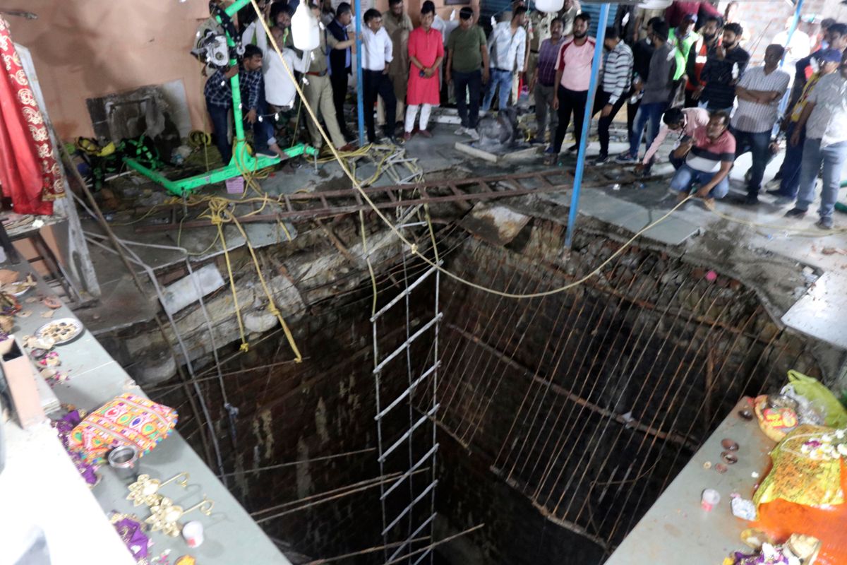 Bildet viser det kollapsede gulvet som var bygget over en gammel brønn i et tempel der mange hinduister var samlet i Indore i India torsdag. AP / NTB