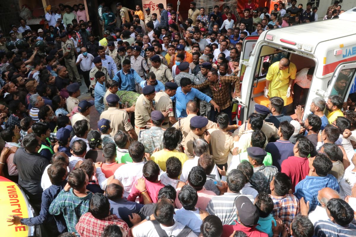Et av ofrene bæres inn i en ambulanse i Indore i India etter ulykken, som skjedde under en hinduistisk festival torsdag. Foto: AP / NTB