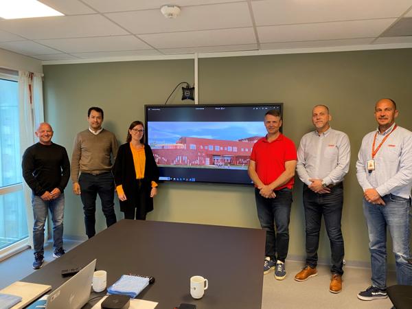 F.v.: Kai M. Svåsand (PPM Prosjekt AS/Fredrikstad kommune), David Zettermann og Anna-Klara Jonsson (Fredrikstad kommune), Raymond Nyborg, Atle Andresen og Ole-Chrisitian Granholt (Park & Anlegg AS). Illustrasjon av skolen på skjerm i midten. Foto: Park Anlegg