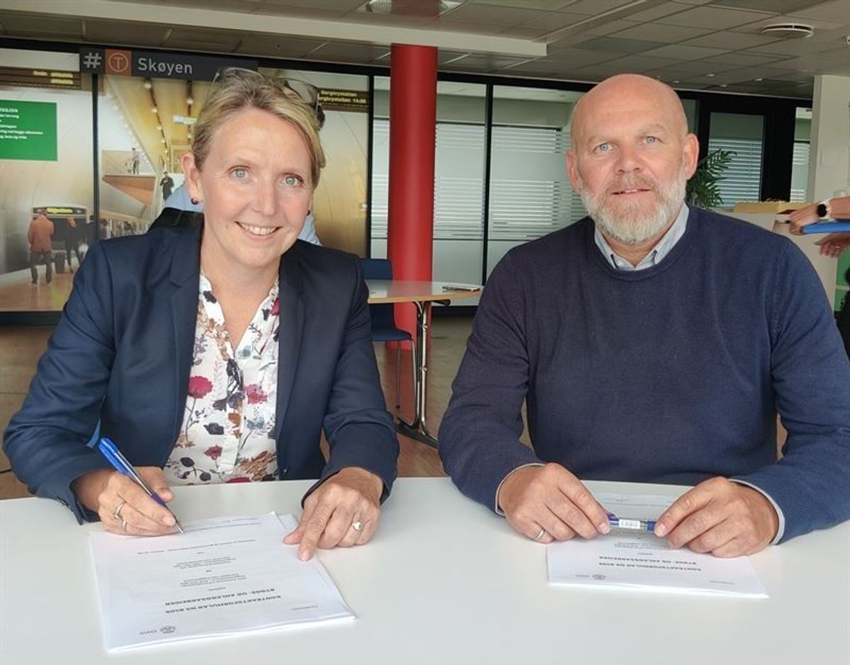 Direktørene Irene Måsøval i Fornebubanen og Neal Nordahl i Veidekke Anlegg signerer kontrakten. Foto: Veidekke
