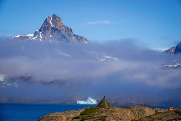 En lavvo og et telt er slått opp med utsikt mot drivende isfjell utenfor Tasiilaq på Øst-Grønland. Foto: Heiko Junge/NTB
