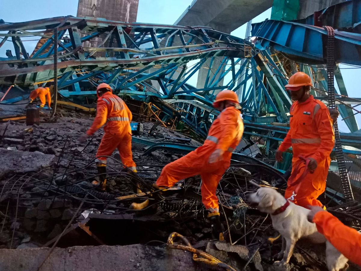 Et katastrofeteam leter gjennom ulykkesstedet utenfor Mumbai i India. Foto: AP/NTB