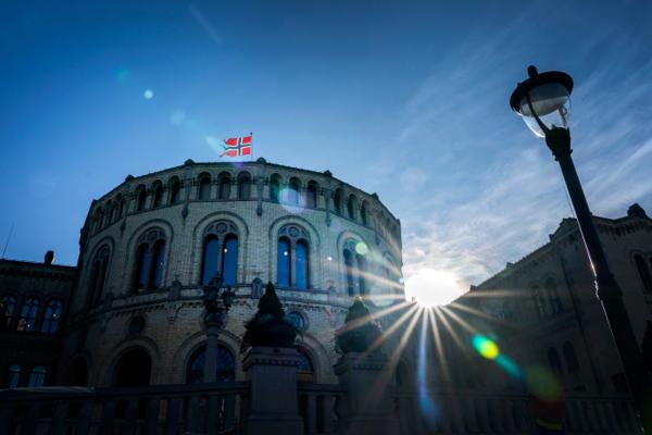 Stortinget med det norske flagg og i motlys. Foto: Gorm Kallestad / NTB