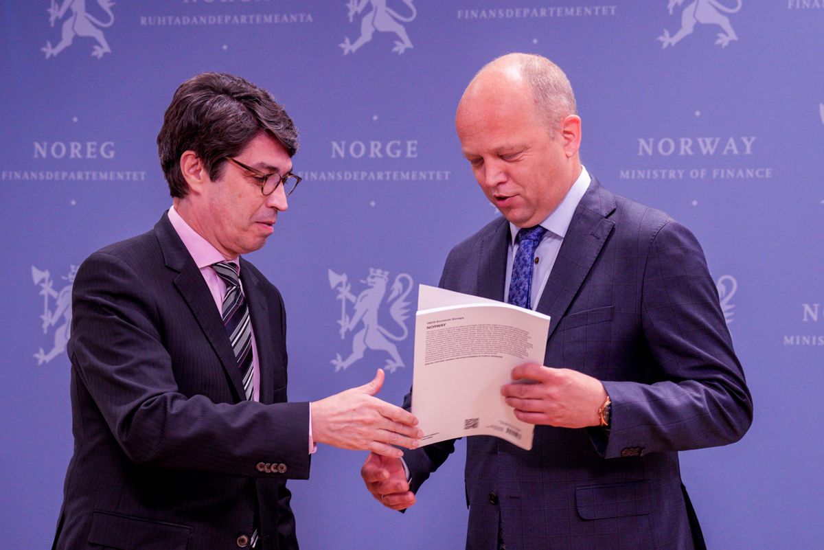 OECD-direktør Luiz de Mello overleverer OECDs toårige gjennomgang av norsk økonomi til finansminister Trygve Slagsvold Vedum (Sp) i Oslo torsdag.