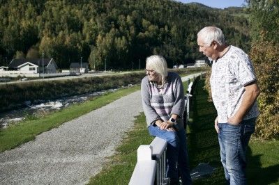 NÆRMESTE NABO: Judit og Håkon Næprud skuer utover Åa, som vanligvis er en snill elv. Men i 2013 tok den hele kjelleretasjen på huset deres.