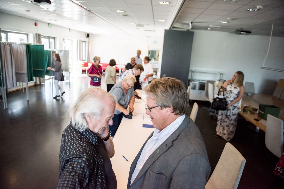 Songdalen-ordfører Johnny Greibesland (Sp) (til høyre) i samtale med sambygding og forfatter Paal-Helge Haugen i valglokalet mandag. Foto: Lisa Rypeng