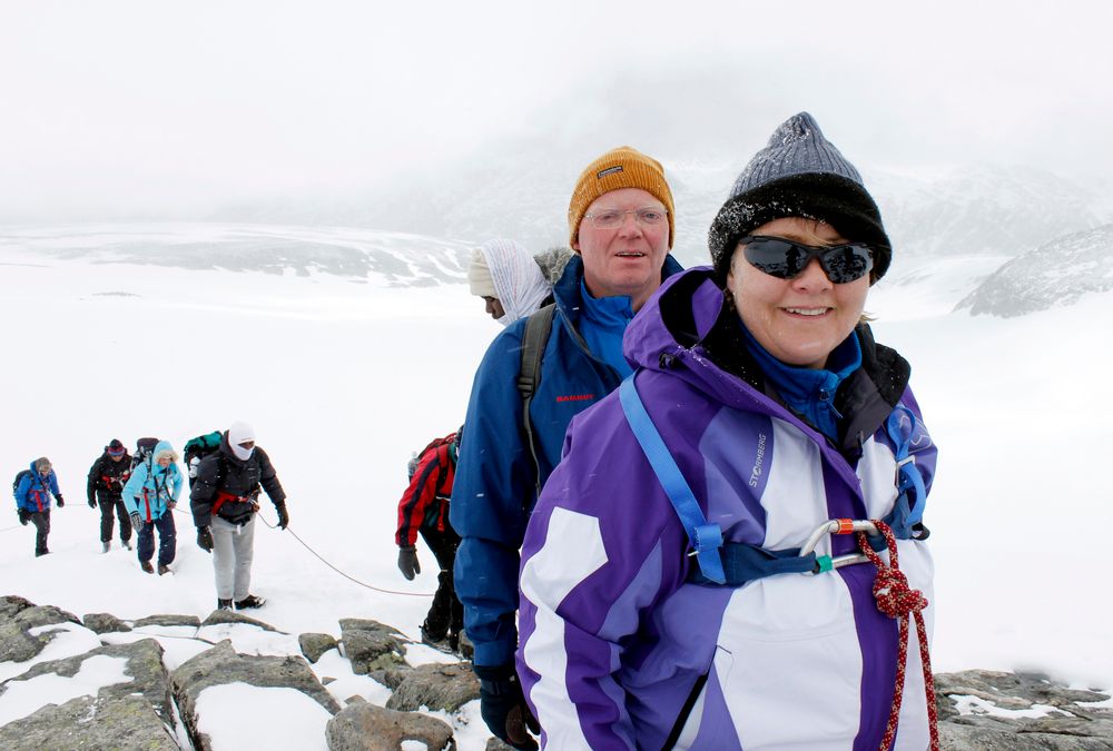 Høyre-leder Erna Solberg og hennes mann Sindre Finnes på vei mot toppen av Galdhøpiggen under integreringsturen Til Topps i regi av Røde Kors lørdag. Foto: Thomas André Syvertsen / Røde Kors / NTB scanpix