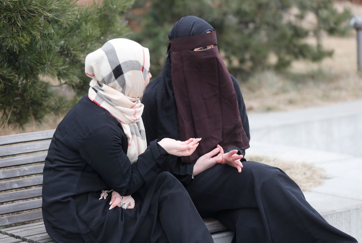 En burka har et heklet "vindu" foran øynene, som gjør det mulig å se ut. Ingen av disse kvinnene bærer burka. Derimot har den ene hijab og den andre (bak) nikab. Illustrasjonsfoto: Lise Åserud / NTB scanpix