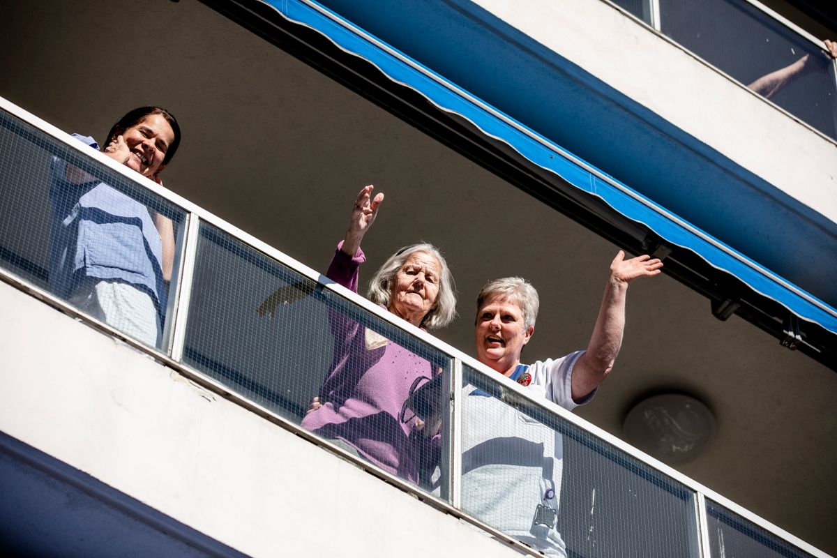 Beboere følger med på utekonsert fra balkongene på Silurveien sykehjem i Oslo.