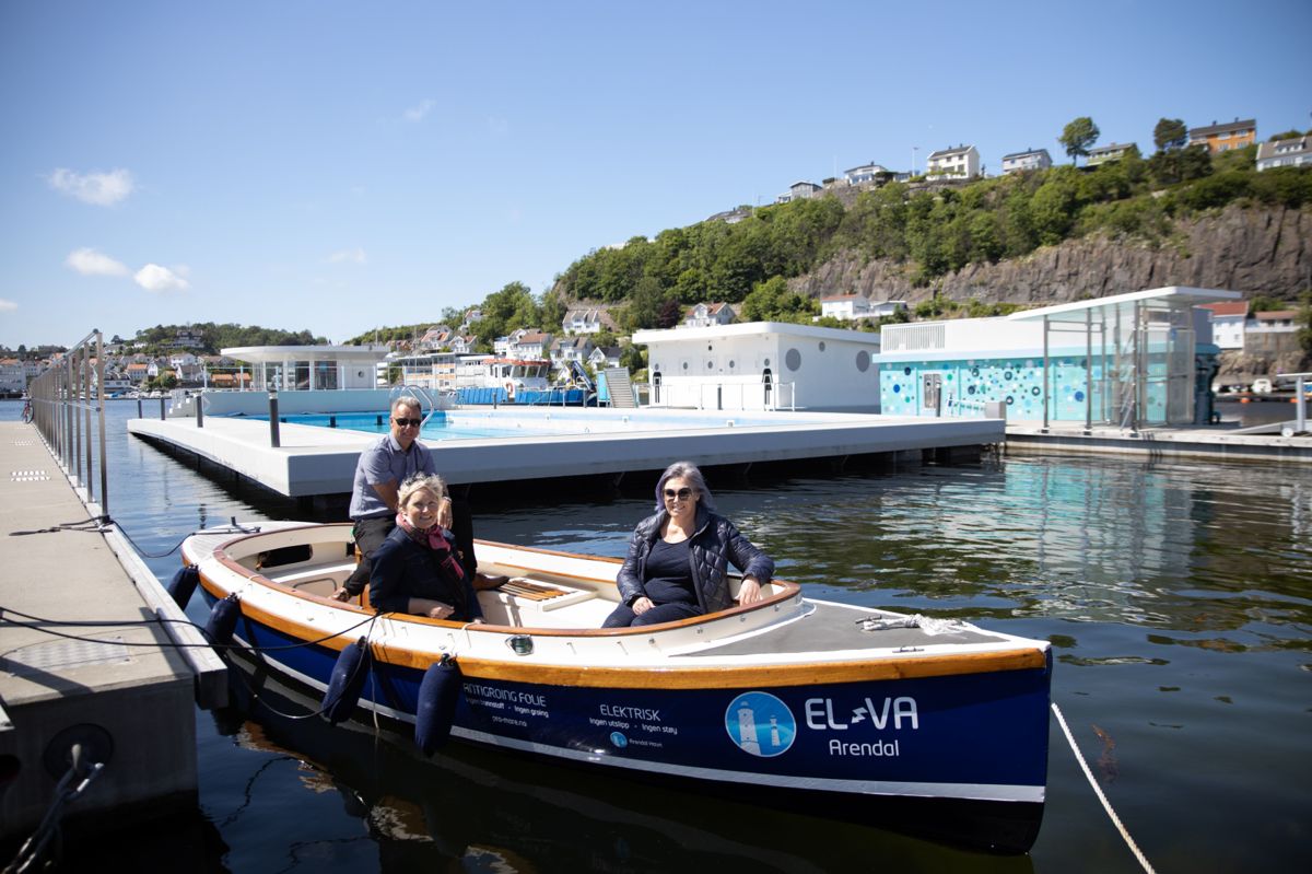 Havnesjef Rune Hvass, klima- og miljørådgiver Ragnhild Marie Hammer og leder for komité for samfunnsutvikling Vanja Grut (Ap) i en elektrisk båt, som tilhører Arendal havn. Går det som de vil, skal de 20 beste plassene i gjestehavna være utstyrt med ladepunkter og reservert elektriske båter innen neste sommer. I bakgrunnen ser vi Arendal havns flytende svømmebasseng, som gjenåpner 20. juni.