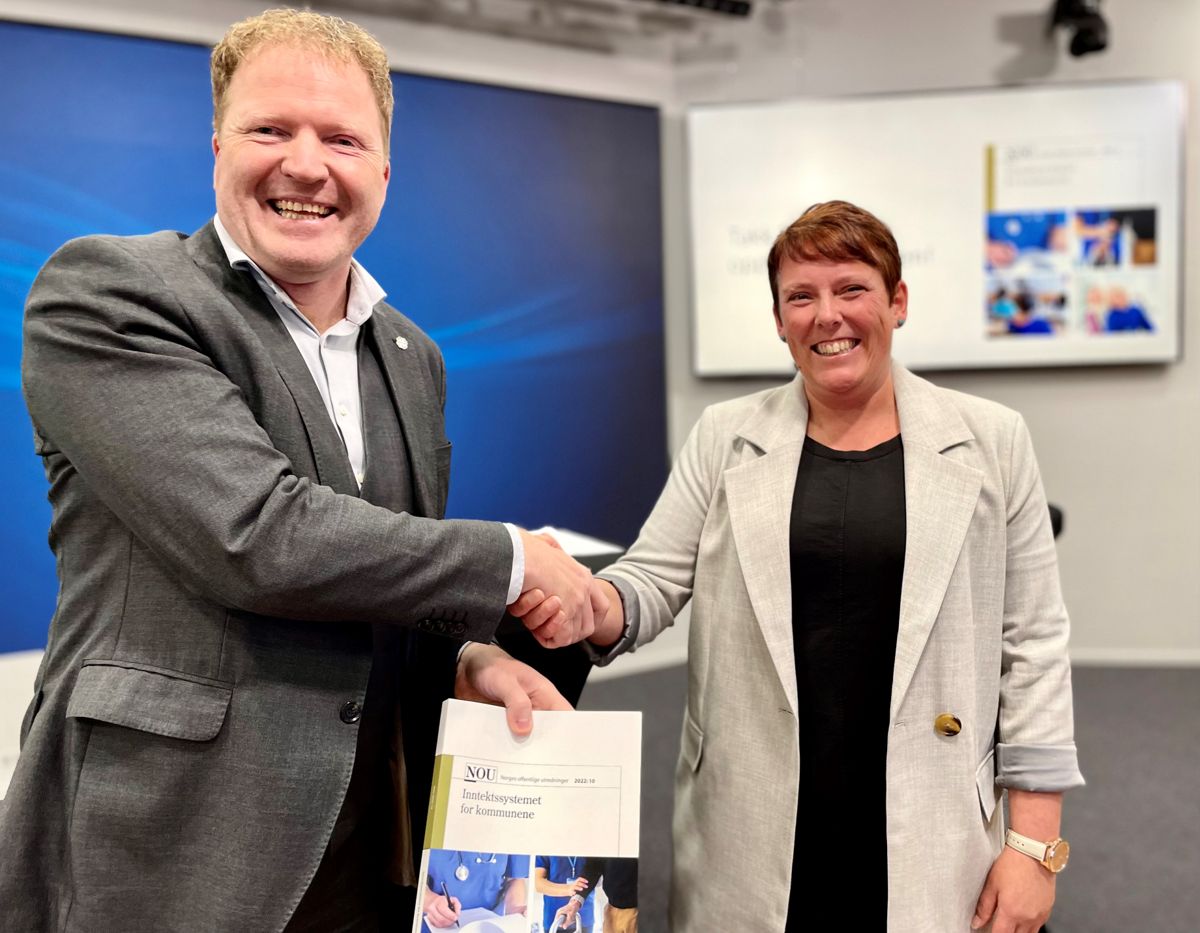 Kommunal- og distriktsminister Sigbjørn Gjelsvik (Sp) får overlevert rapporten fra Inntektssystemutvalget av utvalgsleder Marianne Haraldsvik.