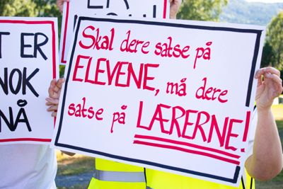 21 lærere ved Nordre Modum ungdomsskole ble tatt ut i streik 29. august. Her holder de fram plakatene som viser streikeparoler.