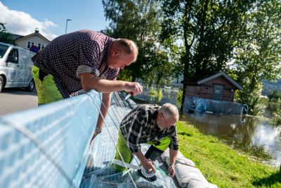 Morten Andersen (t.v) og Per Skogmo fra avdelningen Vei og park i Drammens kommune arbeider med å sikre flombarriererne ved Sandstranda i Krokstad utanfor Drammen.