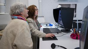 Västra Nylands tidigare arkivarie Gretel Lindström besökte det Journalistiska bildarkivet Joka i Vanda. Projektforskare Joanna Maltzeff förevisar bilder från Västra Nyland som blivit digitaliserade.