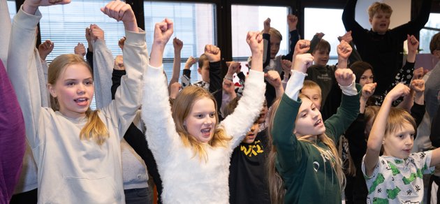 Emilia Puikkonen, Emma Kailanto, Vilma Peltola och Leo Streng står längst fram när elever i musikklasserna i Mårtensdals skola övar inför Skolmusik 2024.