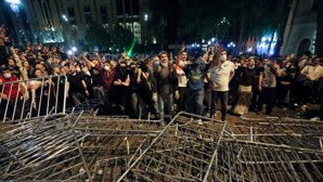 Demonstranter argumenterar med polis på plats vid parlamentsbyggnaden i centrala Tbilisi på tisdagskvällen.