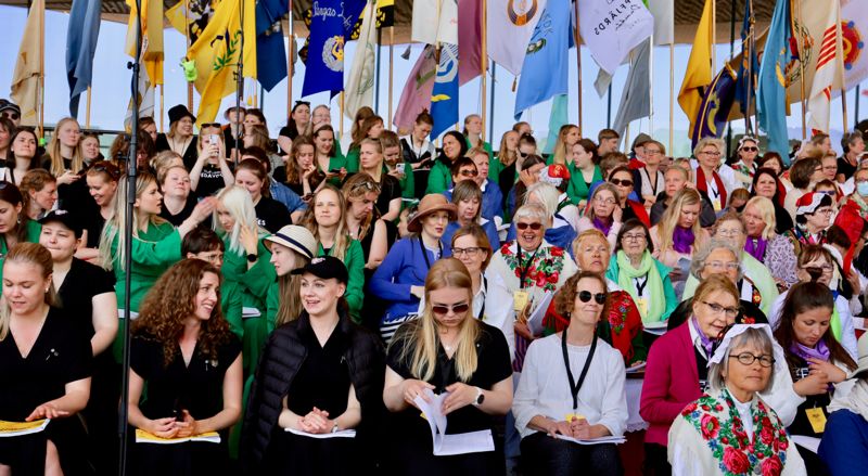 Stämvis sitter de 1 500 sångarna och väntar på att storkonserten ska börja.