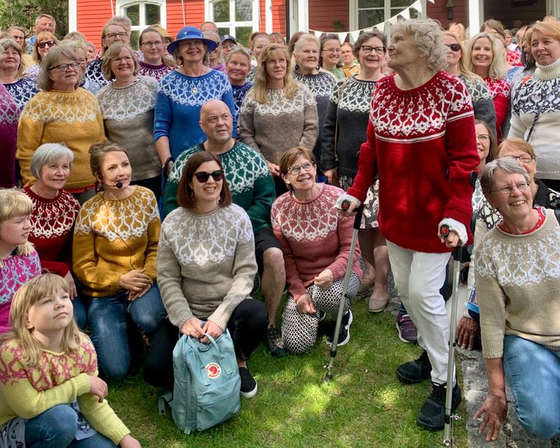 Gassande sol hindrar inte att fansen kommer i ylletröja. Lee Esselström, som designat tröjan, med mikrofon nere till vänster, är omringad av Strömsötröjor i olika modeller och färger.