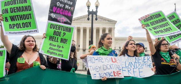 Aborträttsaktivister tar emot beslutet om att riva upp domen som garanterat aborträtten i USA utanför USA:s högsta domstol på fredagen.