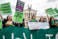 Aborträttsaktivister tar emot beslutet om att riva upp domen som garanterat aborträtten i USA utanför USA:s högsta domstol på fredagen.
