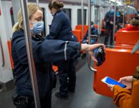 Biljettkontrollanter i uniform kontrollerar biljetterna i metron.