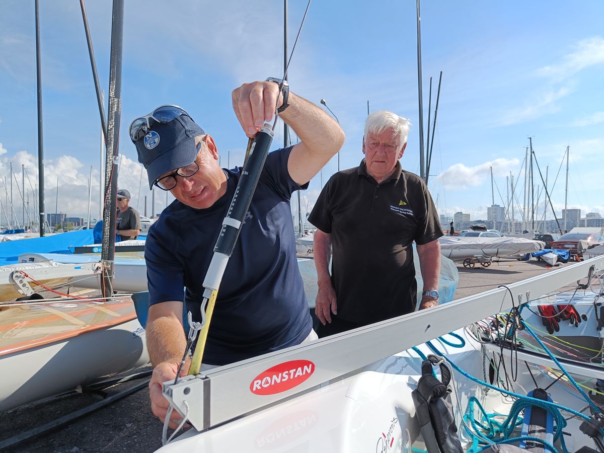 Seglarna John Heyes och Howard Sellers justerar masten inför dagens första start i finnjolle-VM för masters.