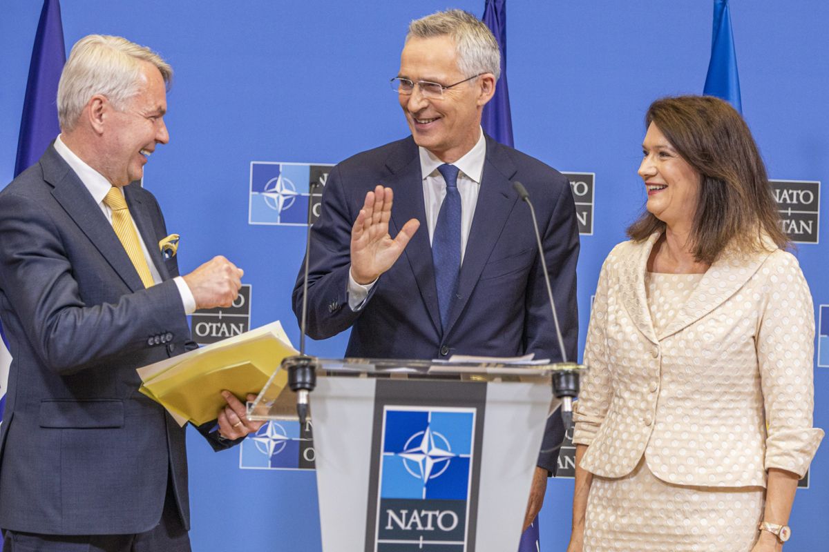 Utrikesminister Pekka Haavisto erbjuder Natos generalsekreterare Jens Stoltenberg en fistbump. I sin vänstra hand bär han det anslutningsprotokoll som nu skickas till 30 medlemsländer för godkännande. Till höger Sveriges utrikesminister Ann Linde (socialdemokrat).