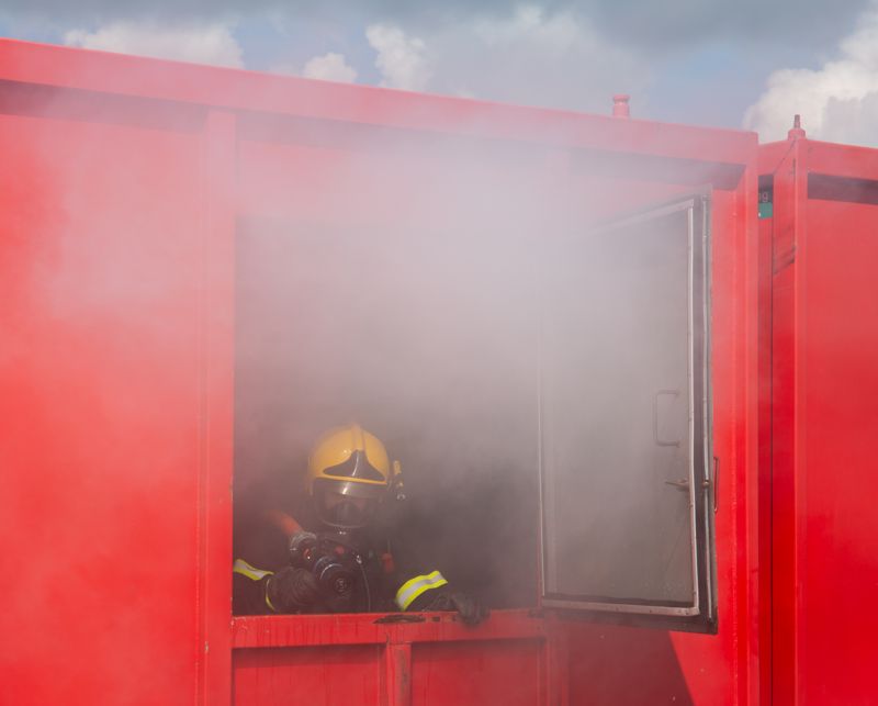 För att simulera en husbrand så fylls en container upp av en rökmaskin och sedan ska deltagaren dra vattenslangen till "fönstret" där hen sedan sätter i gång den.