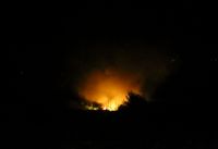 Flammor steg upp från platsen där ett transportplan kraschade i norra Grekland sent på lördagskvällen.